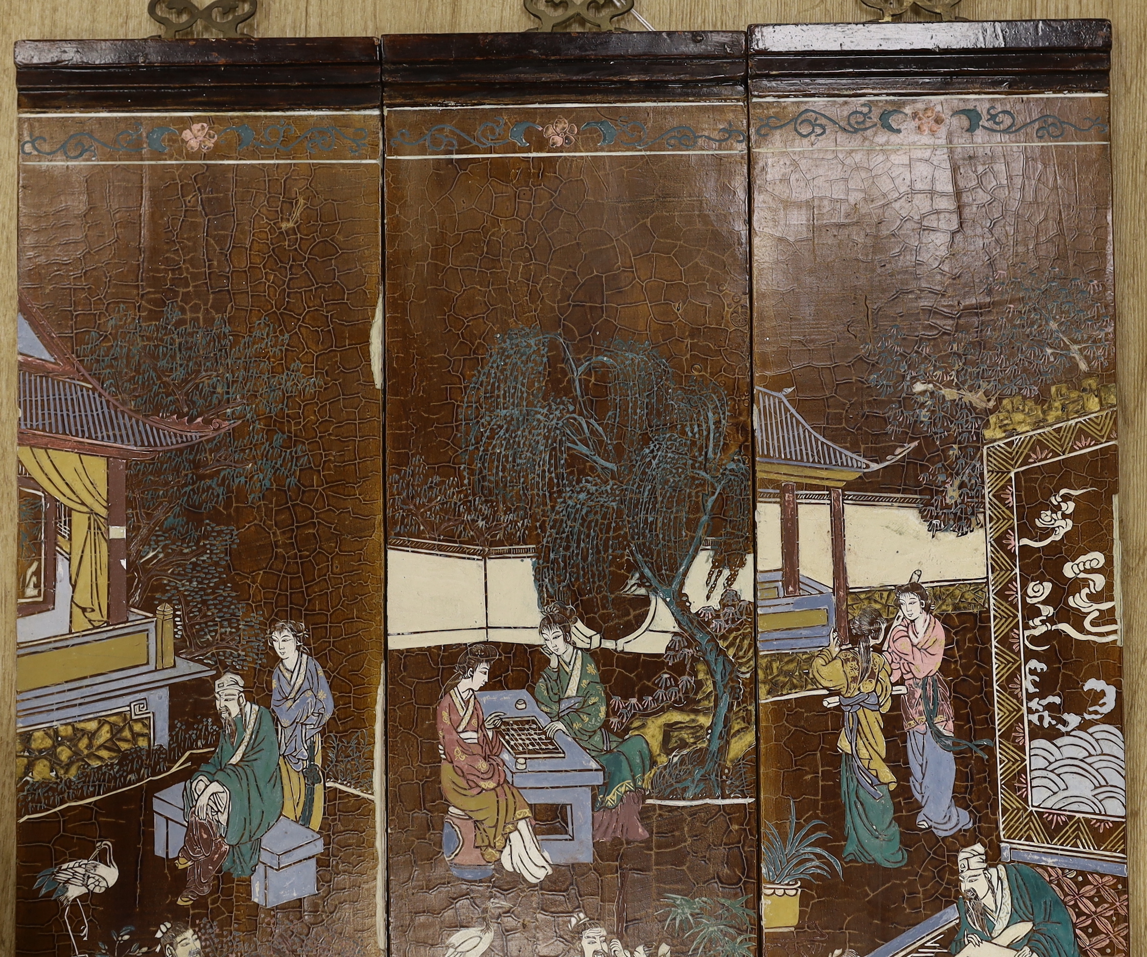Three Chinese wood lacquered panels of domestic scenes, each 69 x 18cm